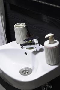 ein weißes Waschbecken mit zwei Tassen drauf in der Unterkunft Happiness Apartment in Ouarzazate + 27 Fotos