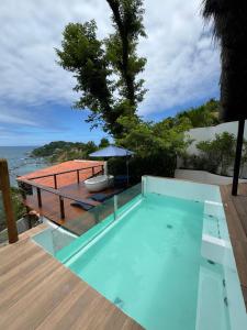 una piscina con terrazza in legno e tavolo di Altavista residence a Morro de São Paulo