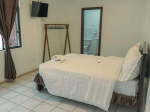 een slaapkamer met een wit bed en een spiegel bij Tikva Hotel in Cuenca +9 foto's
