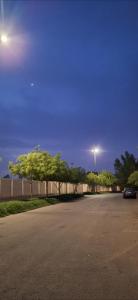 a parking lot with a street with trees and a street light at Sharif Apartments in Medina +5 photos