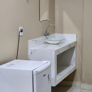 un bagno bianco con lavandino e specchio di Hotel Rocha a Barcarena