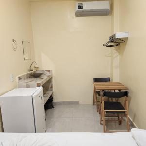 una cucina con lavandino, tavolo e frigorifero di Hotel Rocha a Barcarena