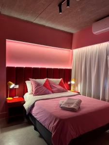 a red bedroom with a bed with a red headboard at Hotel Windsor Mendoza in Mendoza