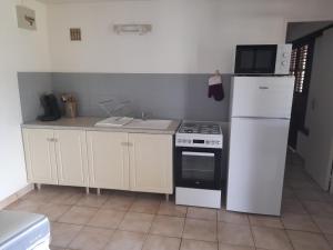 a kitchen with a white refrigerator and a stove at chez Brigitte et Michel in Les Anses-dʼArlets