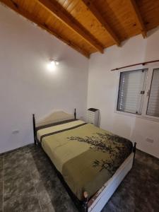 a bedroom with a bed in a room with a window at El Solar in San Antonio Oeste