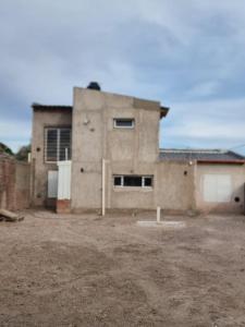 a house in the middle of a dirt yard at El Solar in San Antonio Oeste