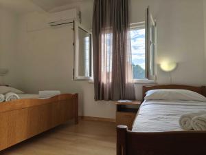 a bedroom with two beds and a window at Pansion Danilo by the sea in Krmčina