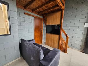 a living room with a couch and a flat screen tv at Residencial Zille - Lofts e Studios in São Miguel dʼOeste