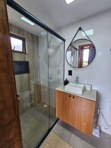 a bathroom with a sink and a shower with a mirror at Residencial Zille - Lofts e Studios in São Miguel dʼOeste +31 photos