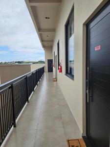 a walkway in a building with a black door at Residencial Zille - Lofts e Studios in São Miguel dʼOeste