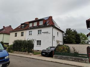 una macchina nera parcheggiata di fronte a una casa bianca di Pension zum Ringelberg a Erfurt