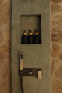a wall with three bottles on a shelf with a charger at The Benison in Ahangama