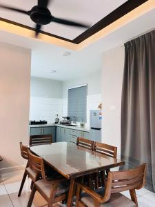 een keuken met een tafel en stoelen en een plafondventilator bij Villa PW 3 Bedrooms in Langkawi Intl