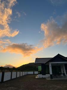 een gebouw met een zonsondergang op de achtergrond bij Villa PW 3 Bedrooms in Langkawi Intl