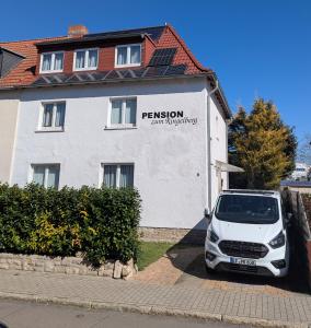 una macchina bianca parcheggiata di fronte a un edificio di Pension zum Ringelberg a Erfurt
