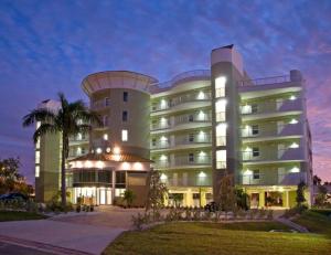 een groot gebouw met een palmboom ervoor bij Modern, Spacious & Clean Beach Getaway in St Pete Beach