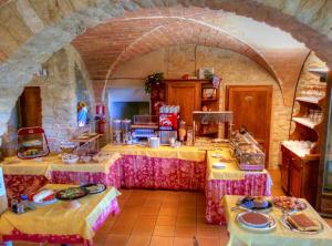 a kitchen with two tables with plates of food at Hotel Residence Villa Rioddi in Volterra