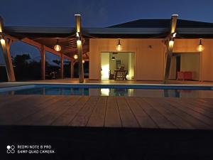 a villa with a swimming pool at night at Villa fleurs d'Antalia in Anse-Bertrand