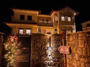 a christmas tree in front of a house at night at Vytina Mont et Sapin in Vitina
