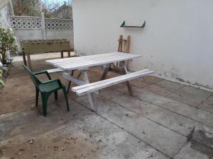 een picknicktafel en een groene stoel op een terras bij Las Cruces, Sector Playa Chica in San Antonio