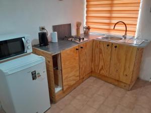 een keuken met een spoelbak, een fornuis en een koelkast bij Las Cruces, Sector Playa Chica in San Antonio