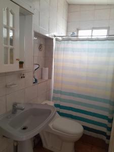 een badkamer met een wit toilet en een wastafel bij Las Cruces, Sector Playa Chica in San Antonio