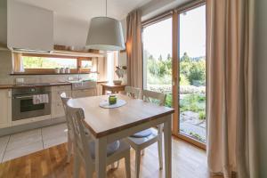 a kitchen with a table and chairs and a large window at Lill' Hill estate & wellness - Anna Apartment in Idrija