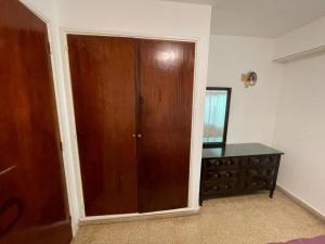 a room with a wooden closet and a dresser at PH con cochera cubierta cerca de la playa in Villa Gesell