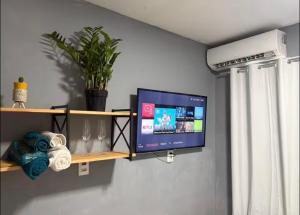 a flat screen tv on a wall in a room at My House in Itajaí