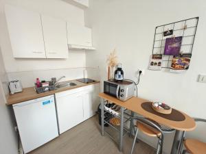 a small kitchen with a table and a microwave at Le studio Mauperthuis in Forges