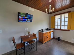 een keuken met een tafel en een eetkamer bij Vila Bella Suítes - Conforto no Centro in Carrancas