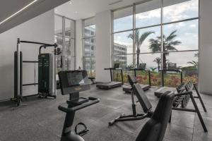 a gym with cardio equipment in a building with windows at Madeira Palace Ocean View in Funchal