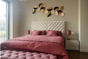 a bedroom with a large bed with a pink comforter at Madeira Palace Ocean View in Funchal +15 photos