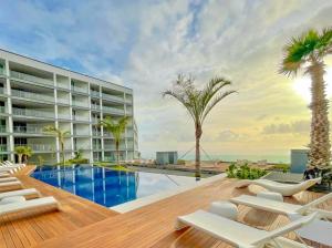 a resort with a swimming pool and palm trees at Madeira Palace Ocean View in Funchal
