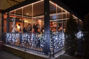 een restaurant met kerstverlichting aan een hek bij Hotel Bel Sit Wellness Spa in Valle di Cadore