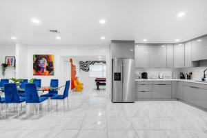 une cuisine avec des chaises bleues et une salle à manger dans l'établissement Miami Dream Home With 4 Bedrooms Game Room And Backyard Oasis, à North Miami Beach