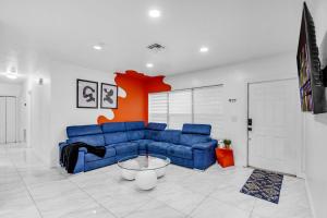 un salon avec un canapé bleu et une table dans l'établissement Miami Dream Home With 4 Bedrooms Game Room And Backyard Oasis, à North Miami Beach