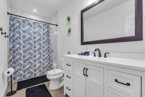 une salle de bains avec lavabo, toilettes et miroir dans l'établissement Miami Dream Home With 4 Bedrooms Game Room And Backyard Oasis, à North Miami Beach 27 autres photos