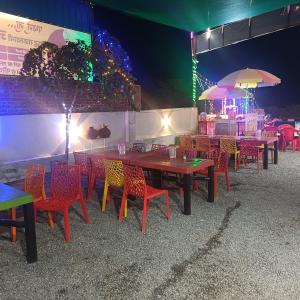 a group of tables and chairs with a bar in the background at Shiv Shakti Hotel And Resort in Mākundgarh