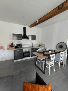 a kitchen and dining room with a table and chairs at Le Grand Mauperthuis F4 in Forges +10 photos