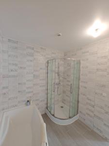 a bathroom with a shower and a bath tub at Le Grand Mauperthuis F4 in Forges