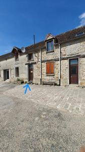 a stone building with a blue arrow in front of it at Le Grand Mauperthuis F4 in Forges