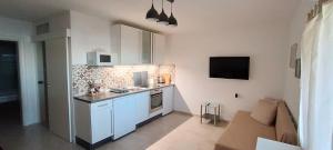 een keuken met witte kasten en een bank in een kamer bij Olcsica Apartment in Klenovica +14 foto's