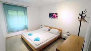 a small bedroom with a bed and a table at Olcsica Apartment in Klenovica
