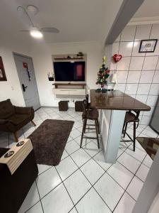 een woonkamer met een televisie en een kerstboom bij Apartamento inteiro 45m, centro, com garagem in Torres