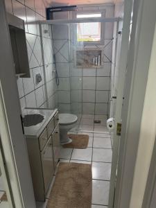 een kleine badkamer met een wastafel en een toilet bij Apartamento inteiro 45m, centro, com garagem in Torres