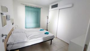 a white bed in a room with a window at Olcsica Apartment in Klenovica