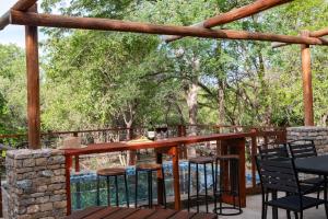 a patio with chairs and a bar on a stone wall at The ChaBo Lodge in Marloth Park