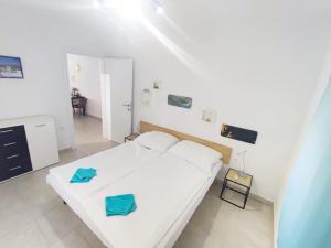 een slaapkamer met een wit bed en een tafel bij Olcsica Apartment in Klenovica