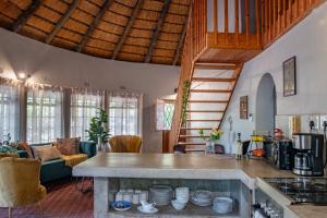 a kitchen and living room with a table with plates at The ChaBo Lodge in Marloth Park